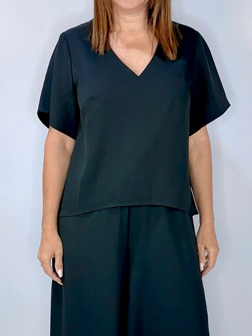 Woman wearing Kerry's Style Sessions black short-sleeve V-neck top paired with matching black pants.