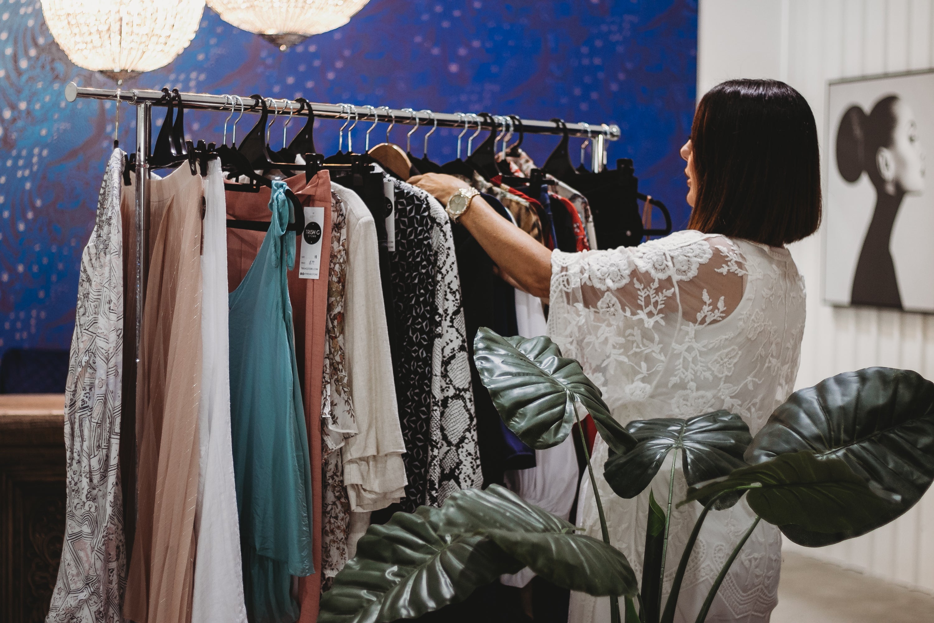 A stylist selecting clothes from a curated rack for a client.