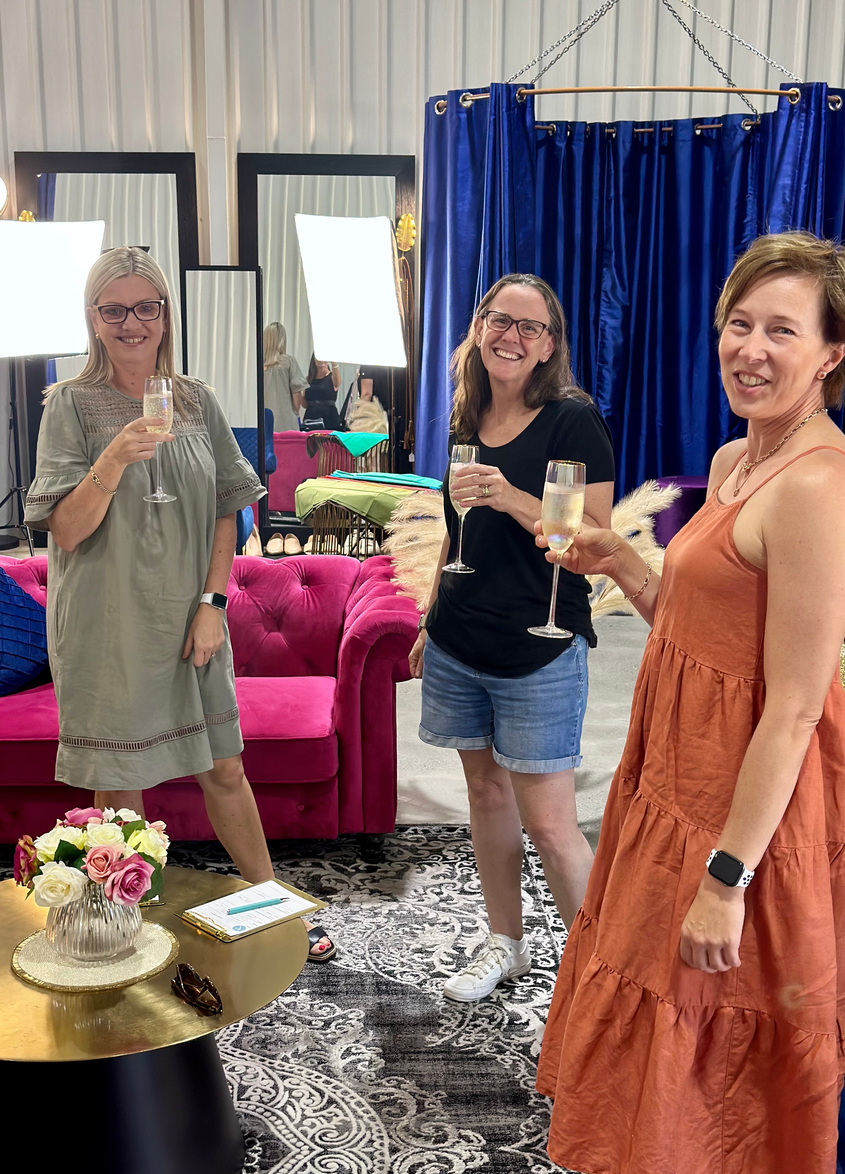Three women enjoying drinks and conversation in a styled lounge setting