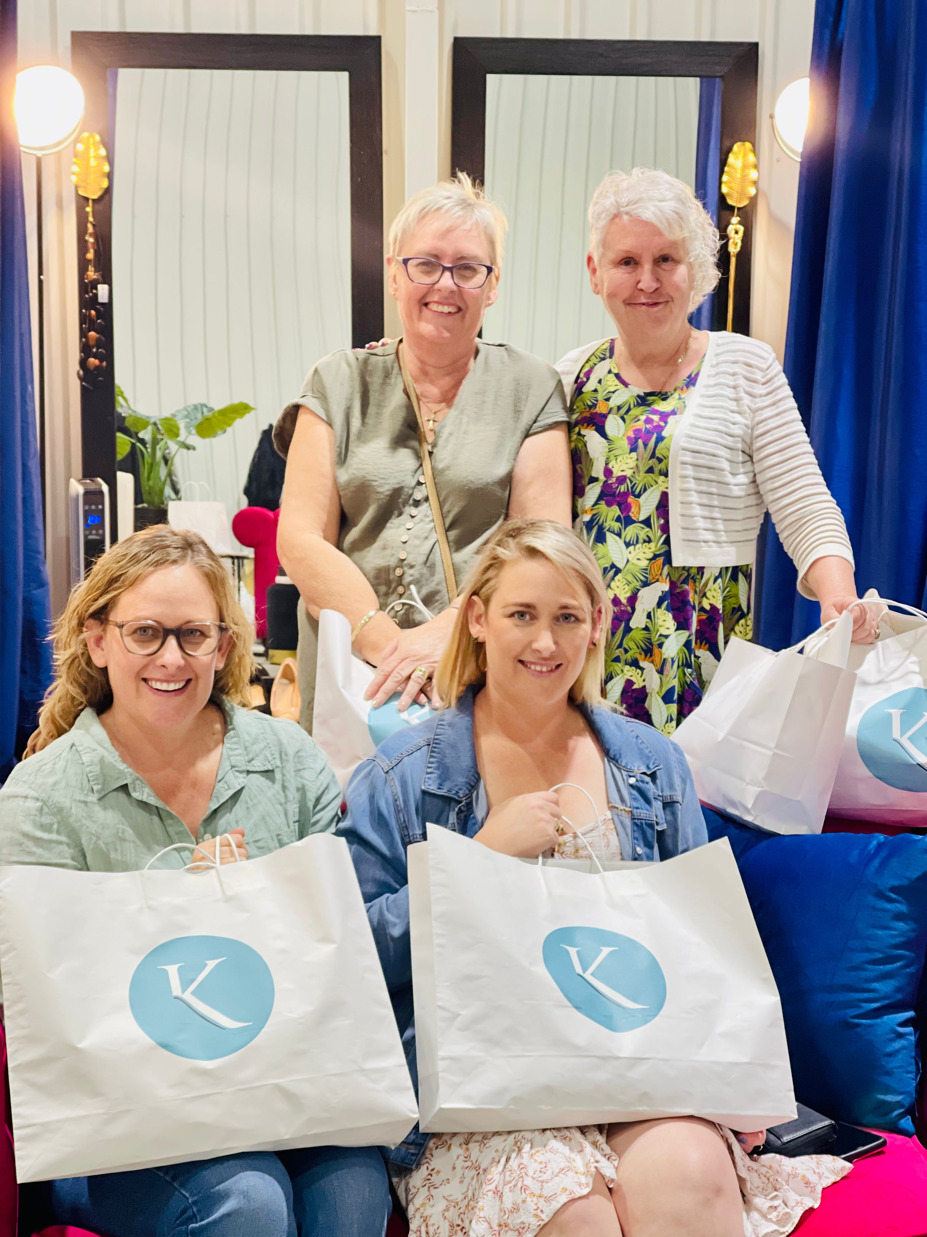 Happy group showcasing their shopping bags after a style session.