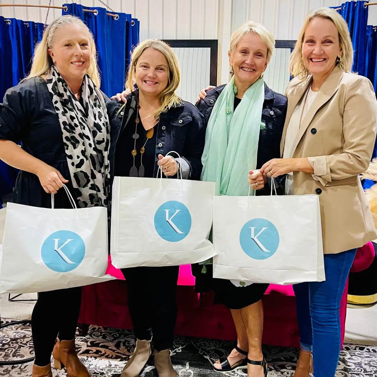 Group of happy women enjoying a shopping and styling session, showcasing their purchases.