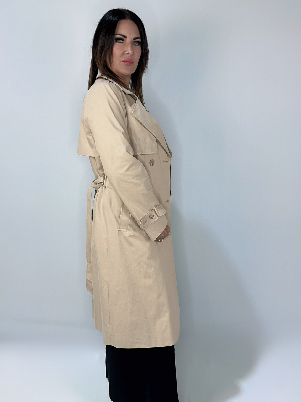 Side view of a woman wearing Kerry's Style Sessions beige trench coat with tie waist.