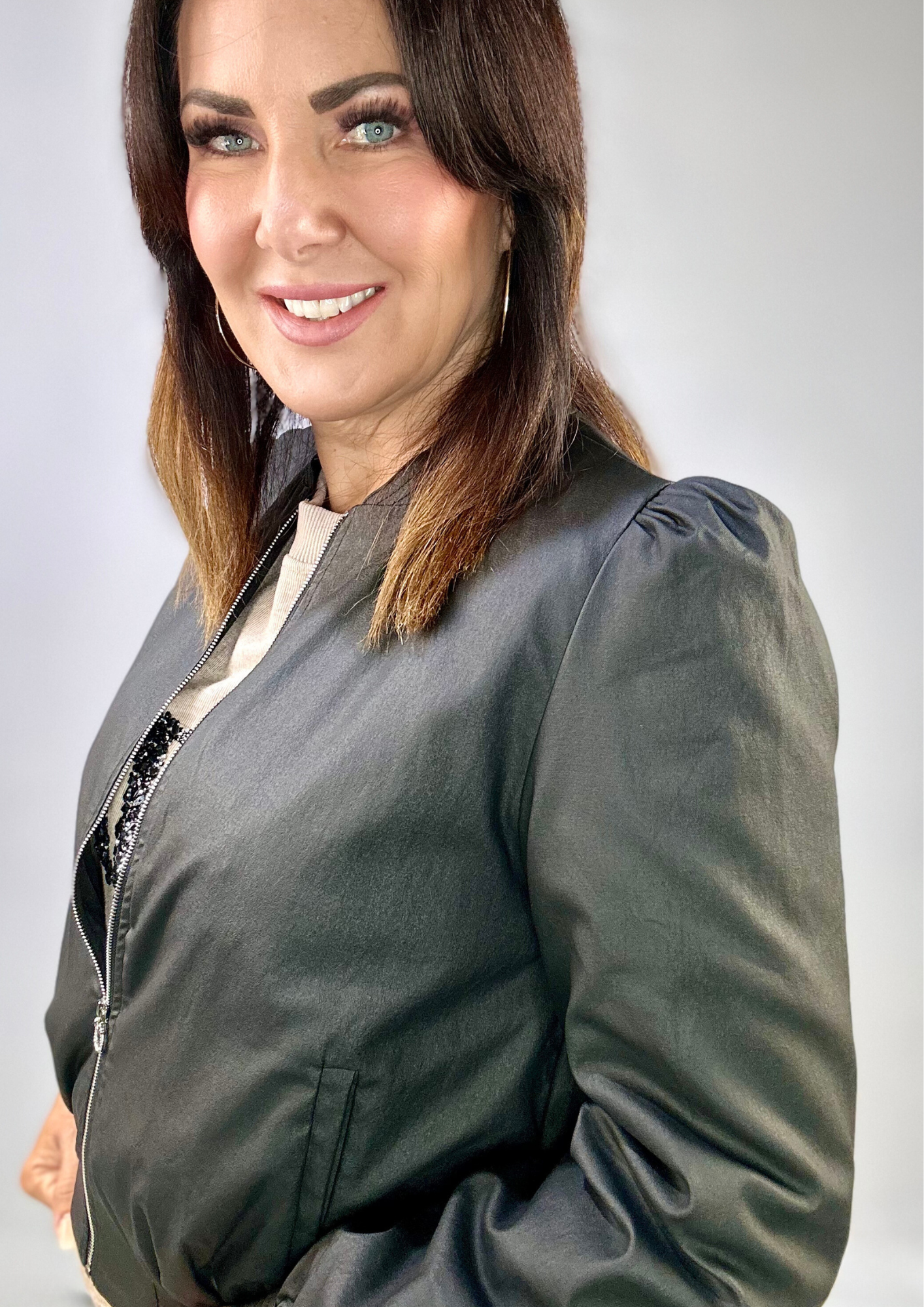 Woman wearing Kerry's Style Sessions black bomber jacket with puff sleeves.