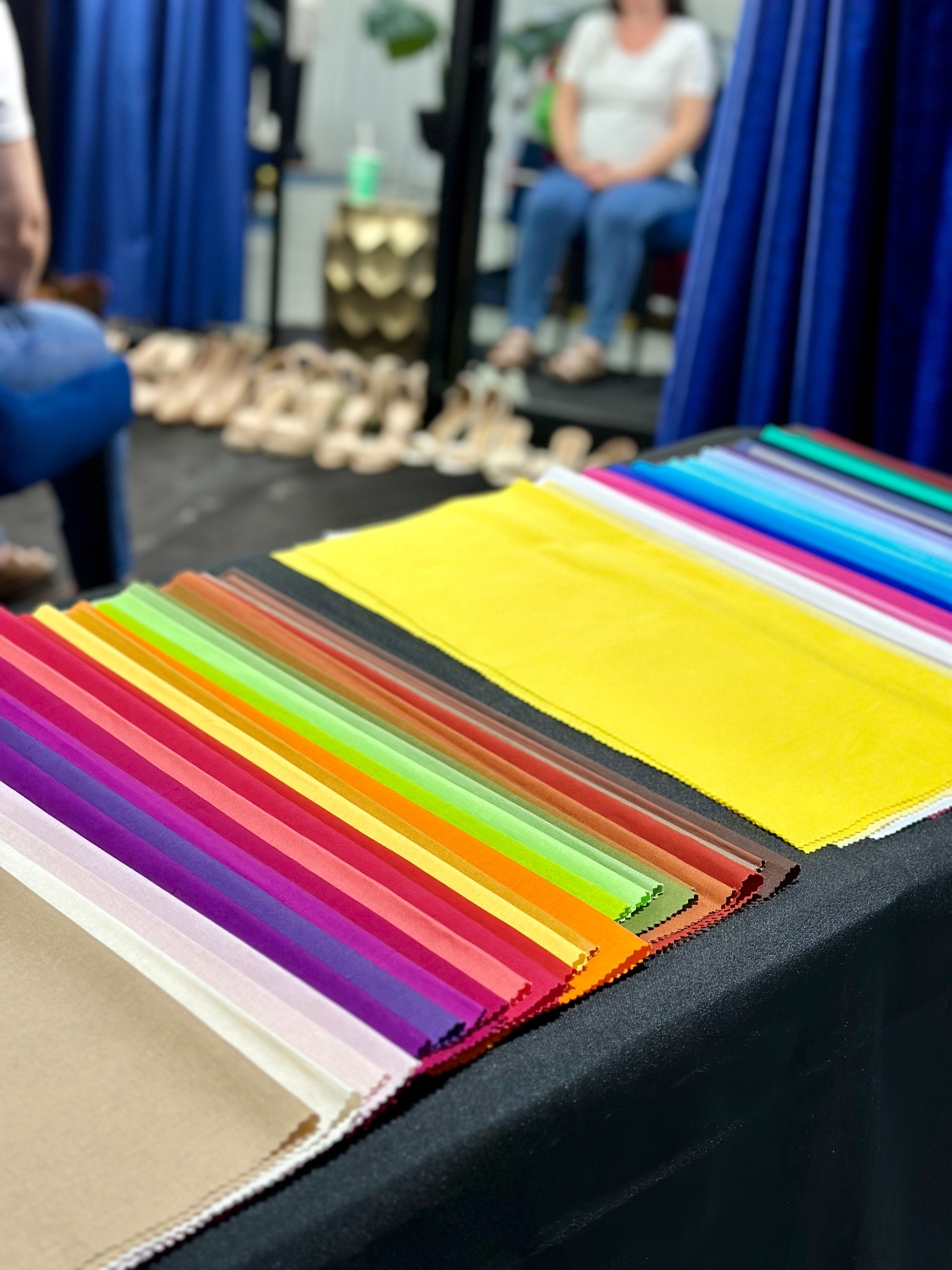 Colour swatches displayed on a table, featuring a variety of vibrant fabric samples arranged neatly.
